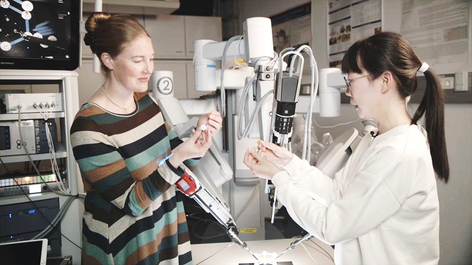 Katherine J. Kuchenbecker in front of the Da Vinci surgical robot.